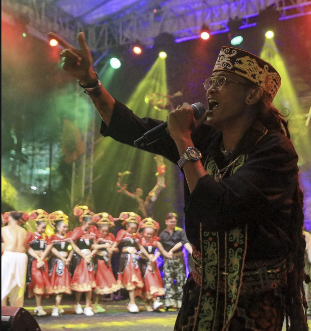 Singer performing with traditional dancers at the Nusantara International Folklore Festival