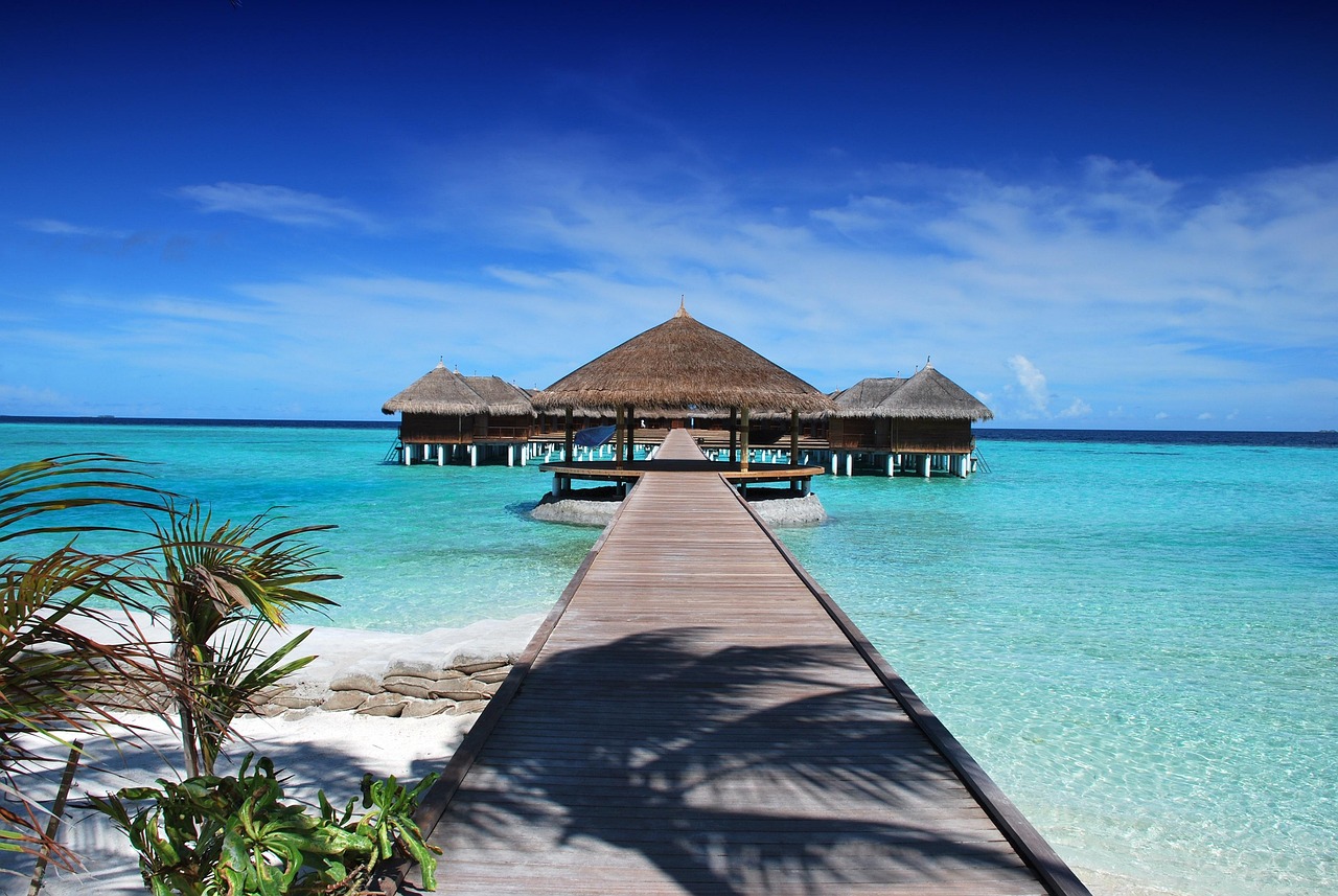 Luxury overwater bungalows above turquoise water at a Nusa Dua-style resort