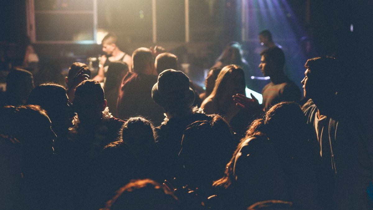 A concert audience facing a softly illuminated stage